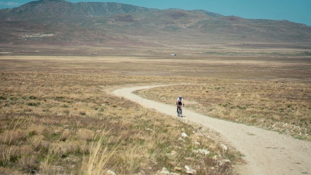 Ciclista en una pista de grava, fotografía ambiental de la guía de gravel